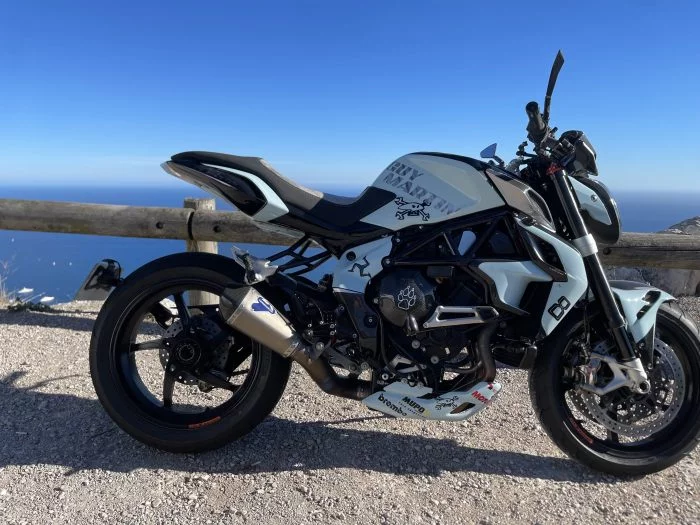 Moto blanche et noire devant un panorama côtier