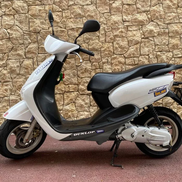 Scooter blanc et noir avec selle beige