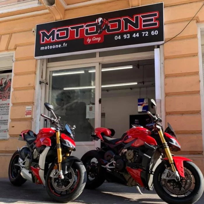 Deux motos rouges devant la devanture de l'atelier Moto One