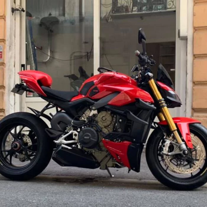Moto rouge et noire garée devant l'atelier Moto One